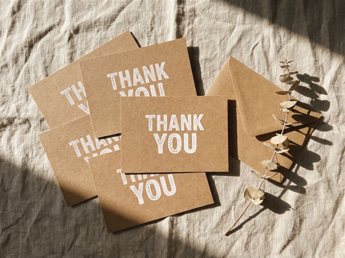 Kraft thank-you cards beside a kraft envelope
