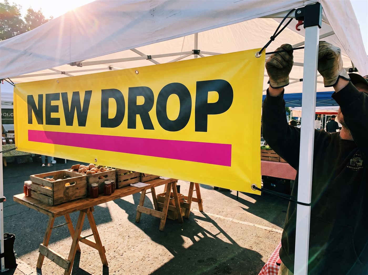 Yellow vinyl banner zip-tied to a market tent